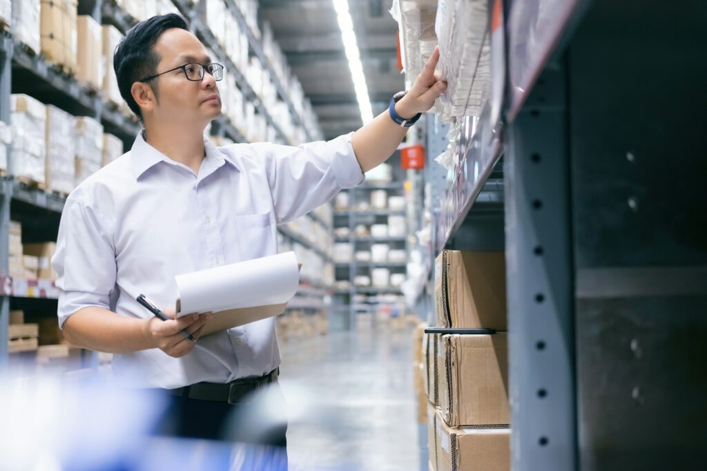 Man warehouse worker checking stock.